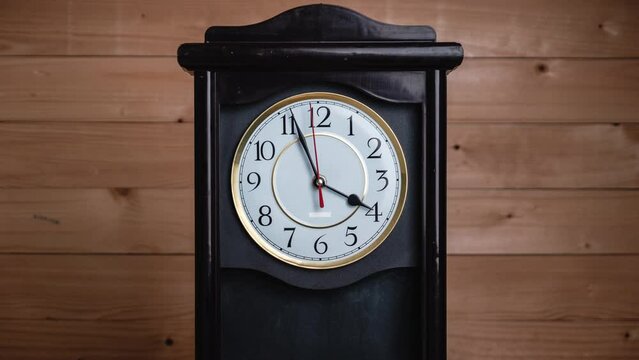 Timelapse of vintage clock with full turn of time hands at 4 am or pm on wooden background. Old Retro wall clock with white circular dial. Old-fashioned antique clock. Arrows second, minute, and hour