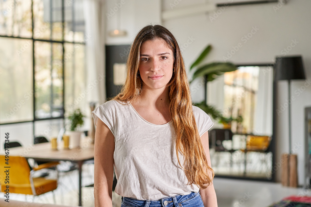 Wall mural confident beautiful blond caucasian woman with serious face standing at home looking at camera. fema