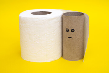 Empty toilet paper roll with sad face for running out of paper on yellow background