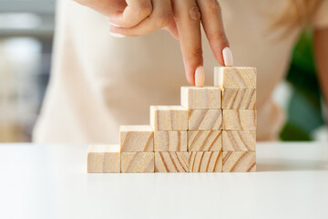 Women hand put wooden blocks in the shape of a staircase