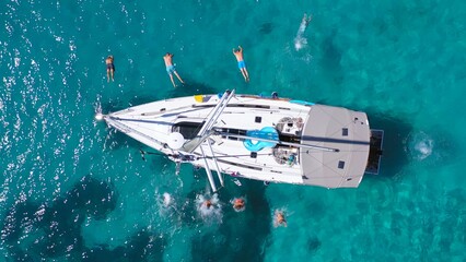 Top view of young friends jumping from sailboat. Yachting. Sail boat party day. Summer luxury boat...