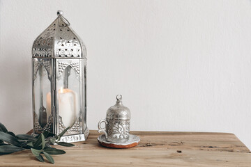 Ramadan Kareem, iftar dinner still life. Ornamental silver lantern with candle and cup with Turkish...