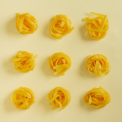 Flat lay top view fettuccine pasta on a yellow pastel background copy space