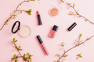 Obraz na płótnie Canvas Makeup cosmetics and accessories on pink background with cherry blossom. Spring concept. Flat lay beauty blogger, top view