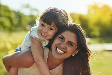 Appreciate every moment spent together. Shot of an adorable little girl and her mother enjoying a piggyback ride in the park.