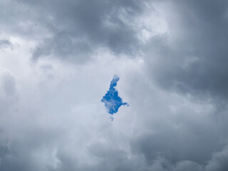 Rhombus hole in thick clouds with a piece of blue sky