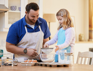 She makes me so proud. Shot of a father helping his daughter sift flour into a bowl.