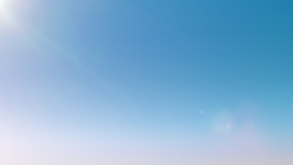 Light blue sky background with sun glare. Clean gradient light blue background. Beautiful light...