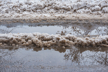 Melting snow and puddles on the road.