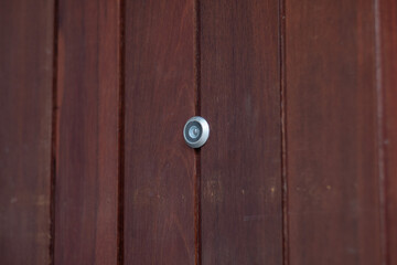closeup eye door on grey wood background, peephole