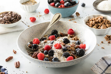 A look inside a bowl of oat yoghurt and toppings of berries, nuts and seeds.