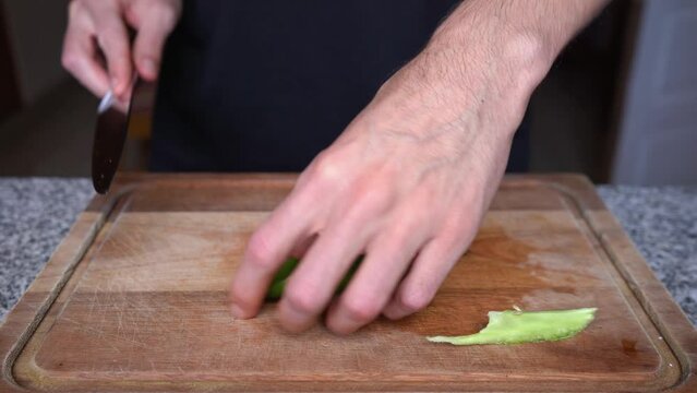Close-up of cook cutting red bell pepper into small cubes or dices