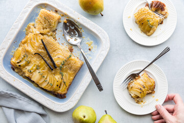 A hand holding a serving of delicious upside down pear cake