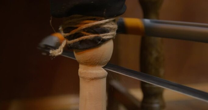 Pirate saws wooden leg of captain sitting on chair with sharp jigsaw on blurred background IN cabin of ship at voyage closeup