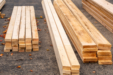 Lumber for a home addition, piled in the driveway - obrazy, fototapety, plakaty