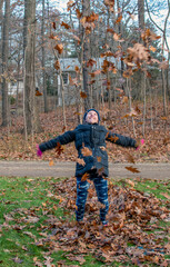  Young girl happiily Playing in fall leaves