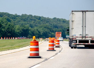 Highway construction season with traffic going past orange traffic cones