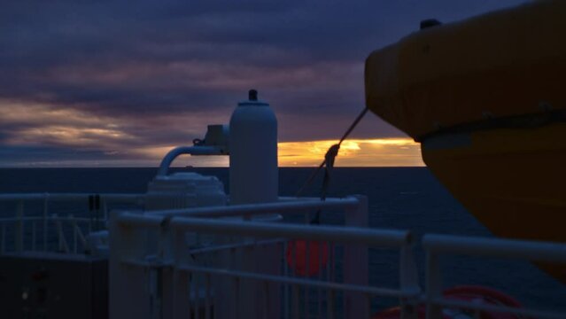 Deck Of Ferry Moving Across Ocean As Sun Sets