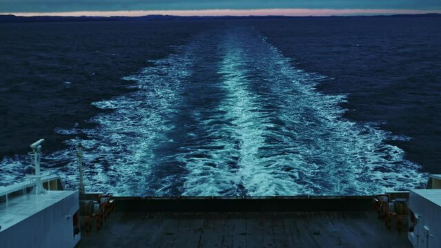Wake In Sea Left By Ferry Leaving Coastline At Dusk