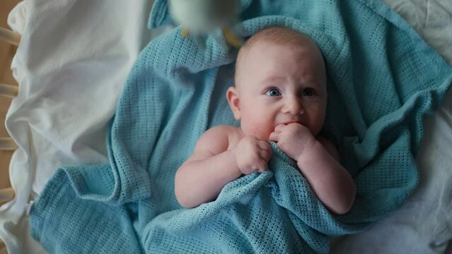 Little cute causian baby boy, smiling at camera, boy looks at the toy and is delighted. vertical video