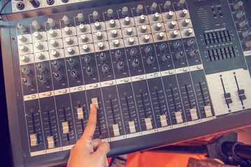Production sound engineer woman hands adjusting volume equalizer voice, mixing console. DJ sound...