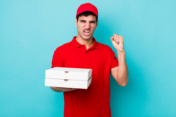 handsome hispanic man shouting aggressively with an angry expression. delivery pizza concept