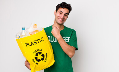 handsome hispanic man feeling happy and facing a challenge or celebrating. ecology concept