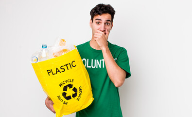 handsome hispanic man covering mouth with hands with a shocked. ecology concept