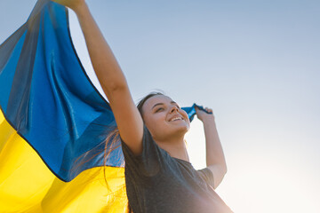Woman holding a yellow and blue flag of Ukraine in outdoors. Independence Day. Flag Day....
