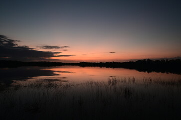 Colorful sunrise reflected in the calm water of Nine Mile Pond in Everglades National Park, Florida.