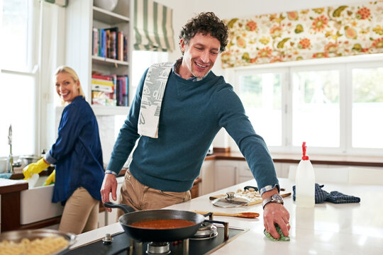 Getting A Head Start On The Post-dinner Cleanup. Shot Of A Happy Couple Cleaning Their Kitchen Together After Cooking Dinner.