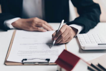 Close up of Business woman pointing and signing agreement for buying house. Bank manager concept.