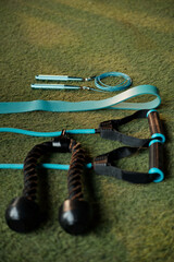 Triceps rope and various resistance bands and resistance strap on turf floor in gym