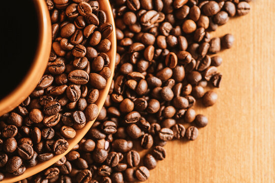 coffee background. coffee mug. copy space with coffee beans. coffee beans on the dining table. closeup of coffee beans. coffee beans on a plate