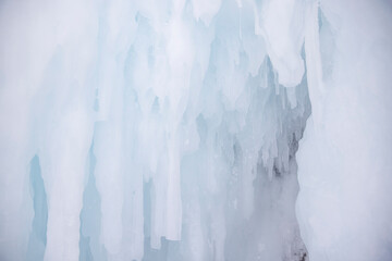 Frozen icicles light blue and white background, beautiful white ice, abstract ice background, lake Baikal