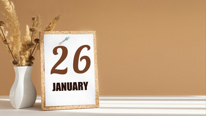 january 26. 26th day of month, calendar date.White vase with dead wood next to cork board with numbers. White-beige background with striped shadow. Concept of day of year, time planner, winter month
