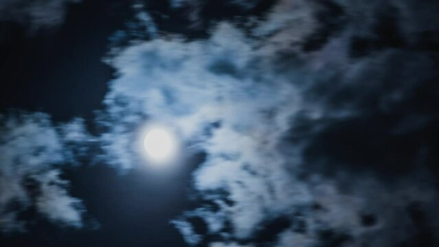 Close up timelapse shot with moon passing trough the clouds in the middle of the night