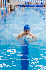 hispanic young man swimmer athlete wearing cap and goggles in a swimming training at the Pool in Mexico Latin America	