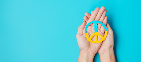 Support for Ukraine in the war with Russia, Hands holding symbol of peace with flag of Ukraine. Pray, No war, stop war, stand with Ukraine and Nuclear Disarmament