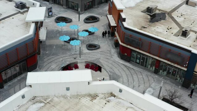 Shoppers walking through outdoor mall in winter in Canada by fire