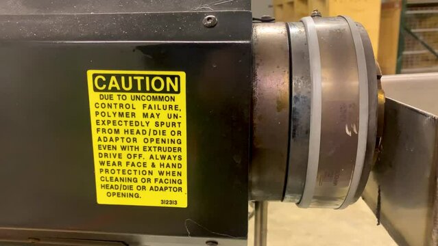 Caution sign on extruder machine for extrusion manufacturing process