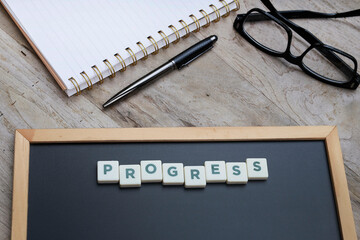 Business progress reporting concept,  PROGRESS letterings on the black chalkboard
