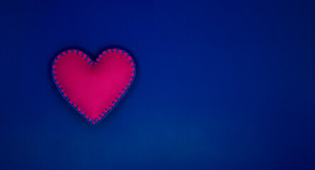Handmade felt heart over blue background