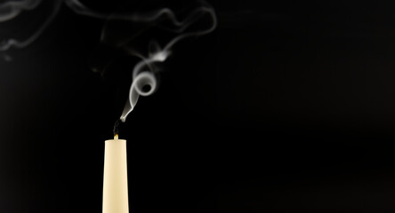 Blown out candle over a black background