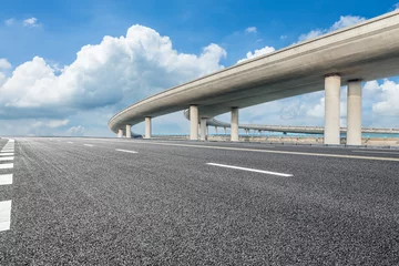 Fototapeten Asphalt highway and bridge under blue sky © ABCDstock