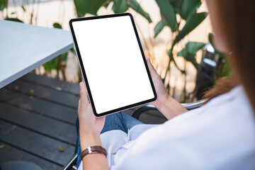 Mockup image of a woman holding digital tablet with blank white desktop screen in the outdoors