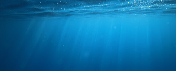 ocean underwater rays of light background, under blue water sunlight