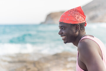 african male person happily enjoying the summer looking at ocean