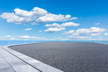 Empty asphalt road platform and lake under blue sky