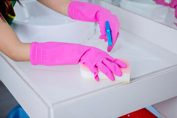 Housewife hands cleaning a sink in bathroom